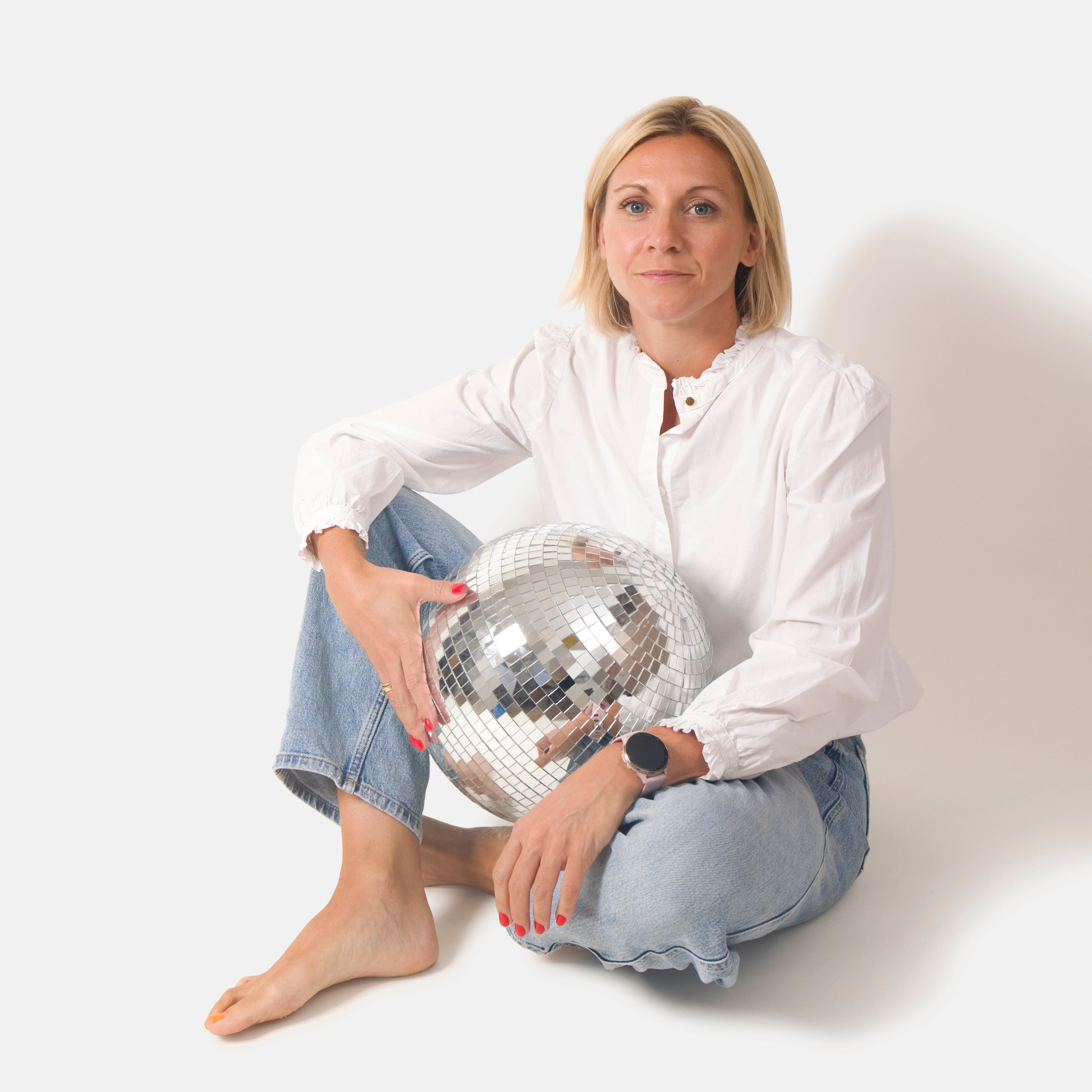 Laurian, founder, holding a disco ball against a white background
