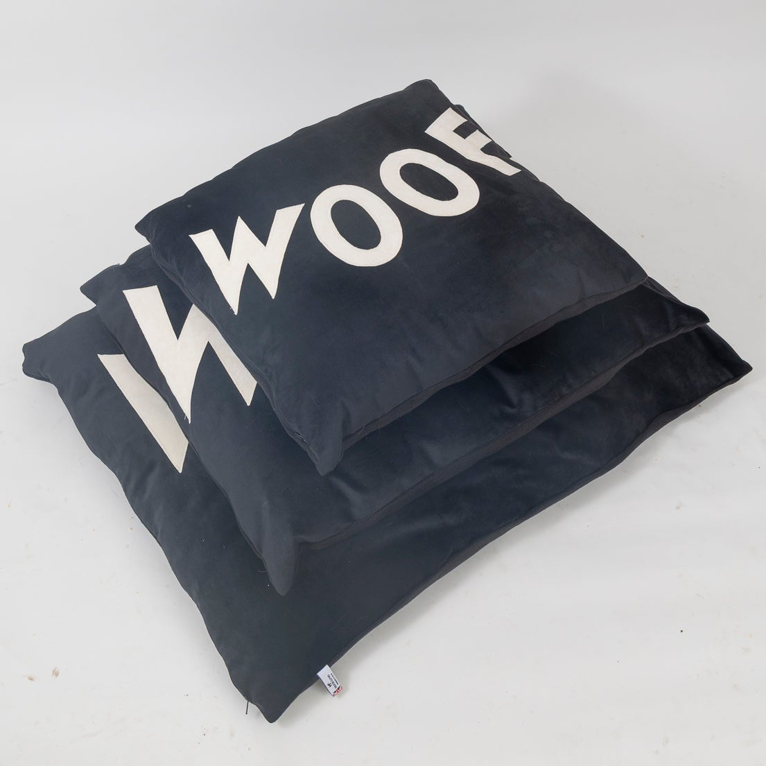 Black dog bed with 'Woof' text on a white background